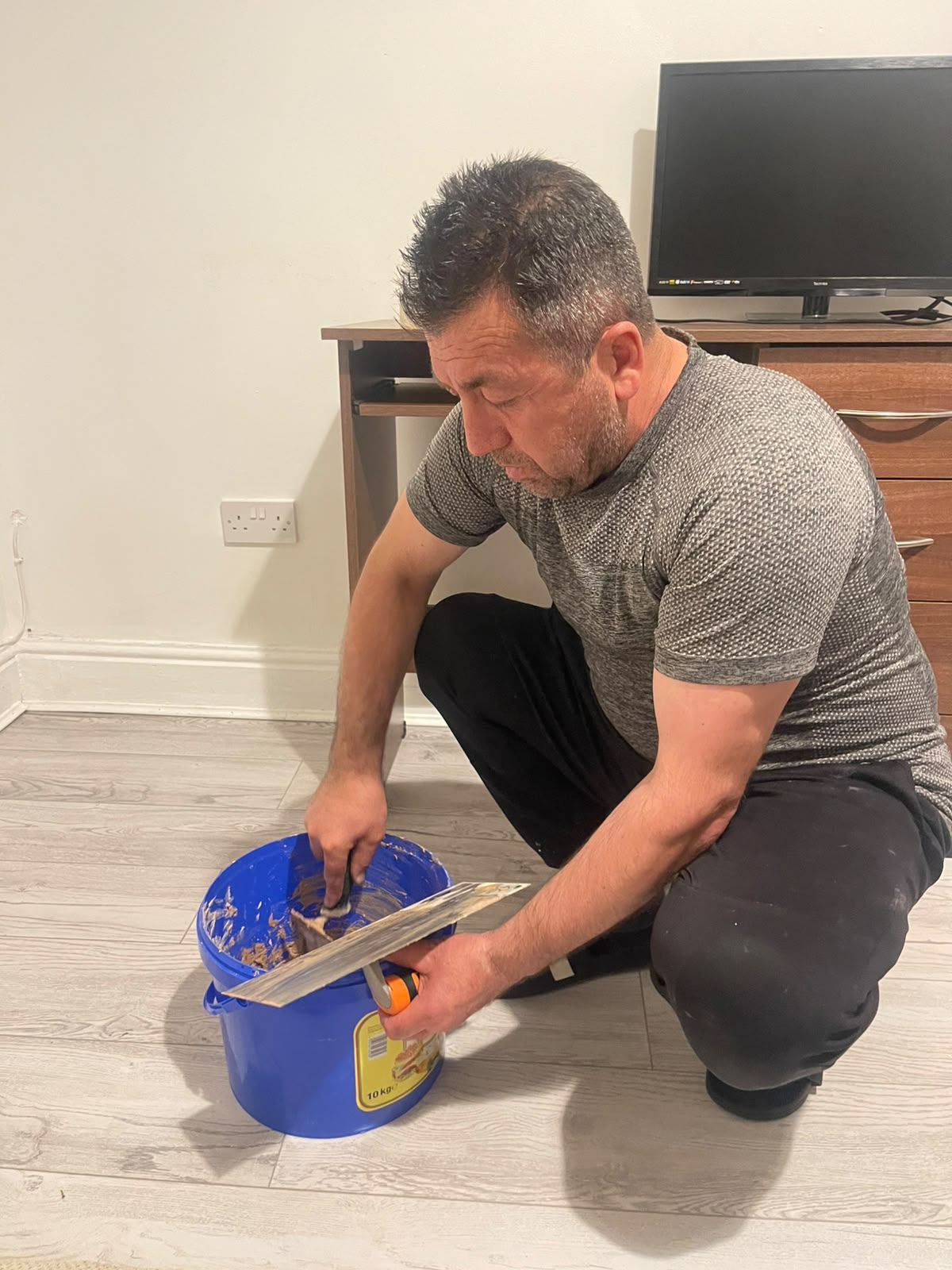 A Ceylin decorator preparing plaster by hand